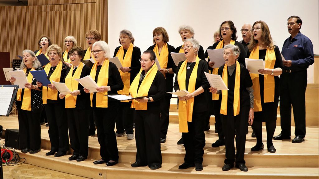 Choir with ladies wearing matching orange scarfs