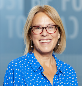 Blonde woman in glasses and blue polka dot top